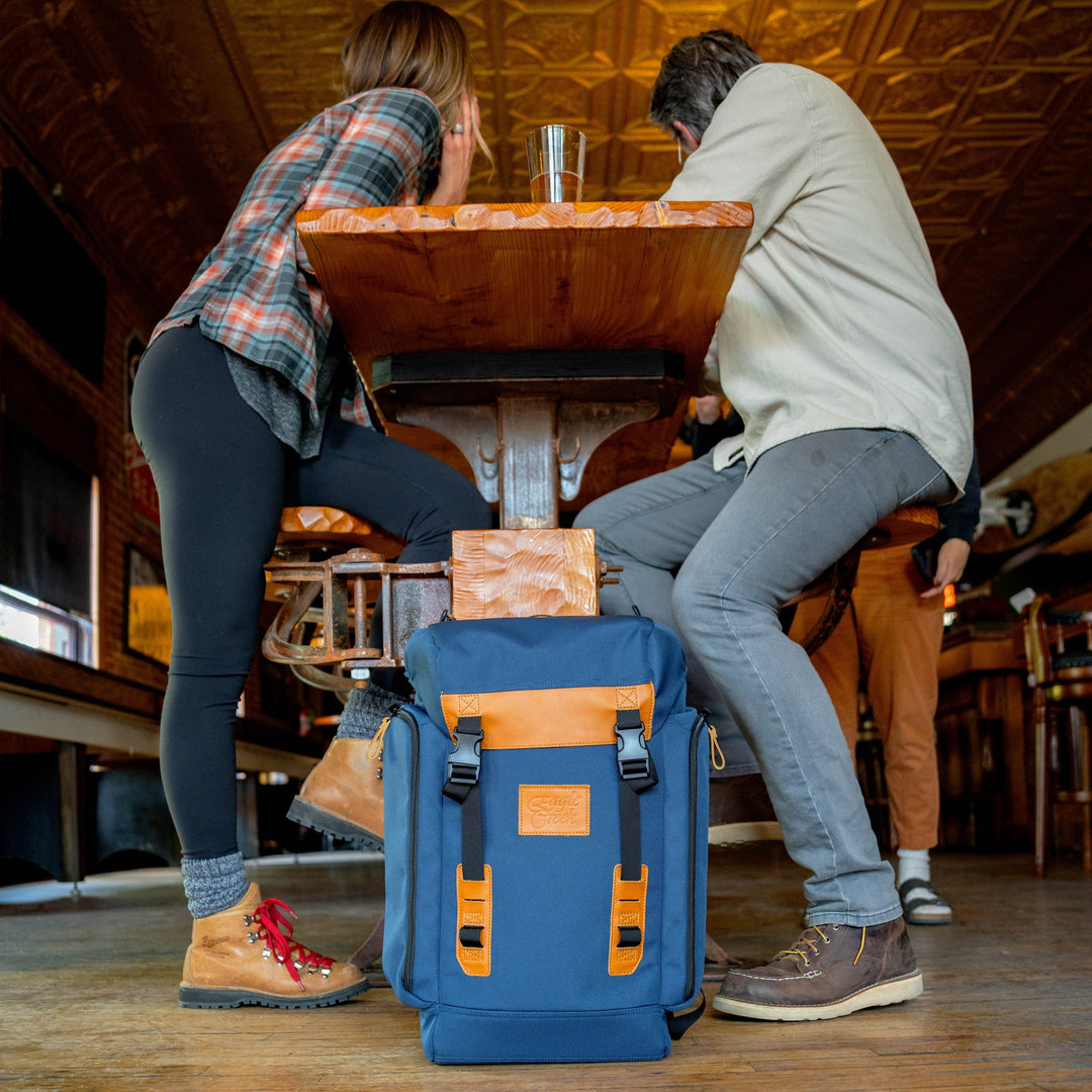 Eagle Creek Backpack sits on floor at bar in San Mateo, CA as couple grabs a drink