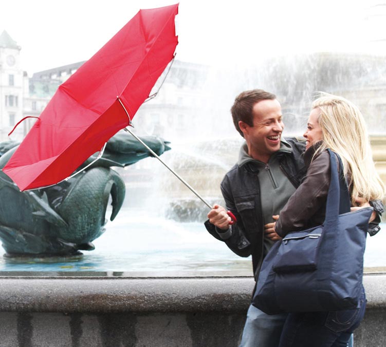 man holding broken umbrella