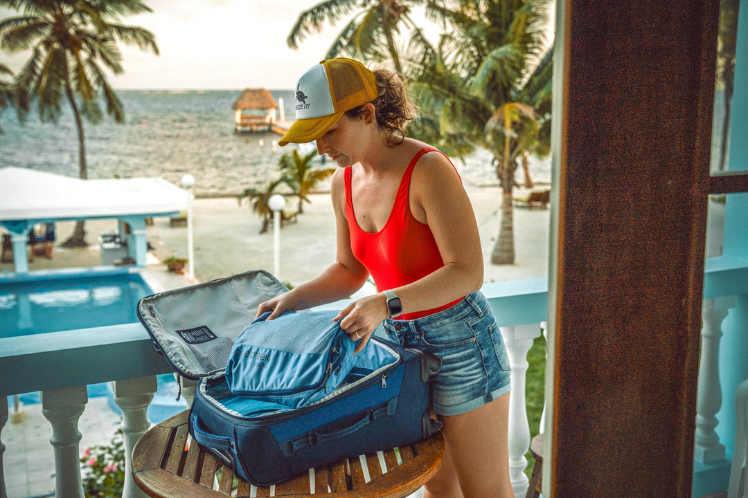 Woman in beach resort packs her international luggage