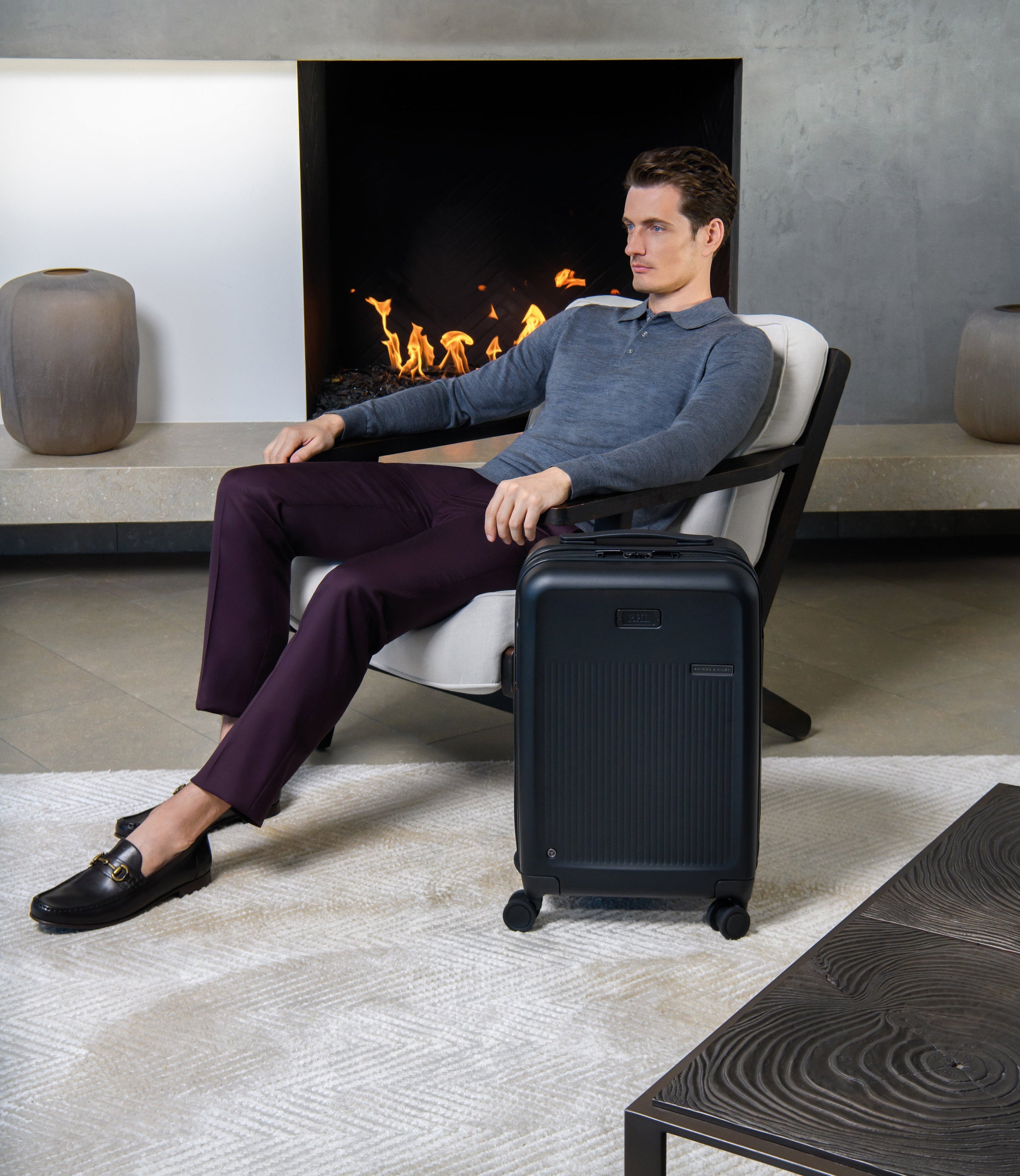 briggs and riley sympatico luggage man sitting by fireplace