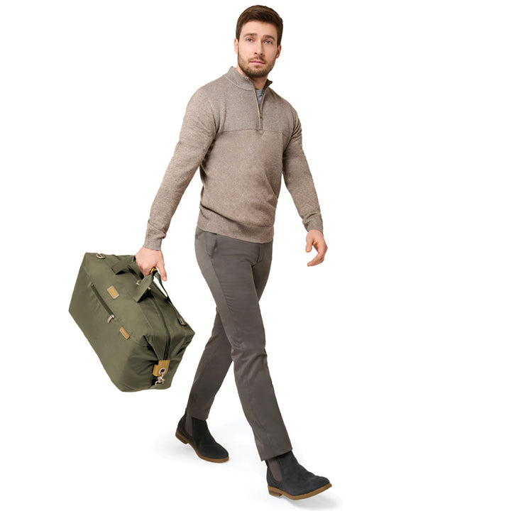 Six foot tall male model carrying Olive Green Weekender Duffle Bag from Briggs & Riley luggage collection