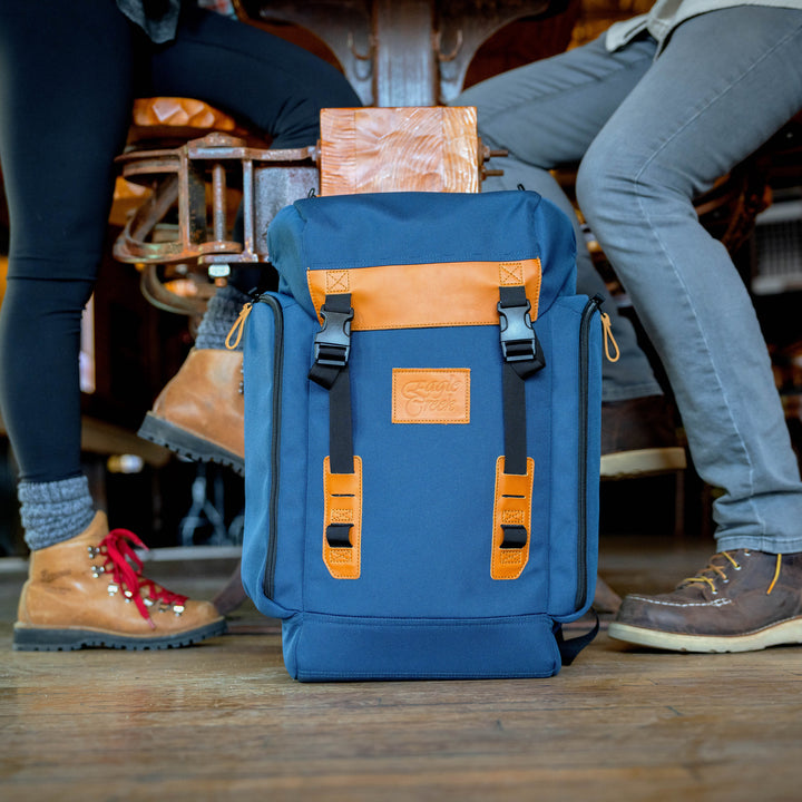 Eagle Creek Origin Series Klettersack in color Classic Blue sitting on floor while woman and man in hiking boots eat lunch
