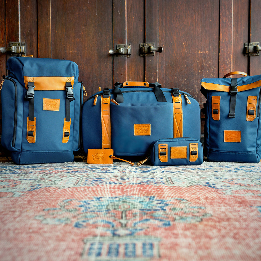 Eagle Creek Origin Series bags sitting together on floor including Eagle Creek Origin Series Klettersack backpack all in matching blue color with orange leather touch points