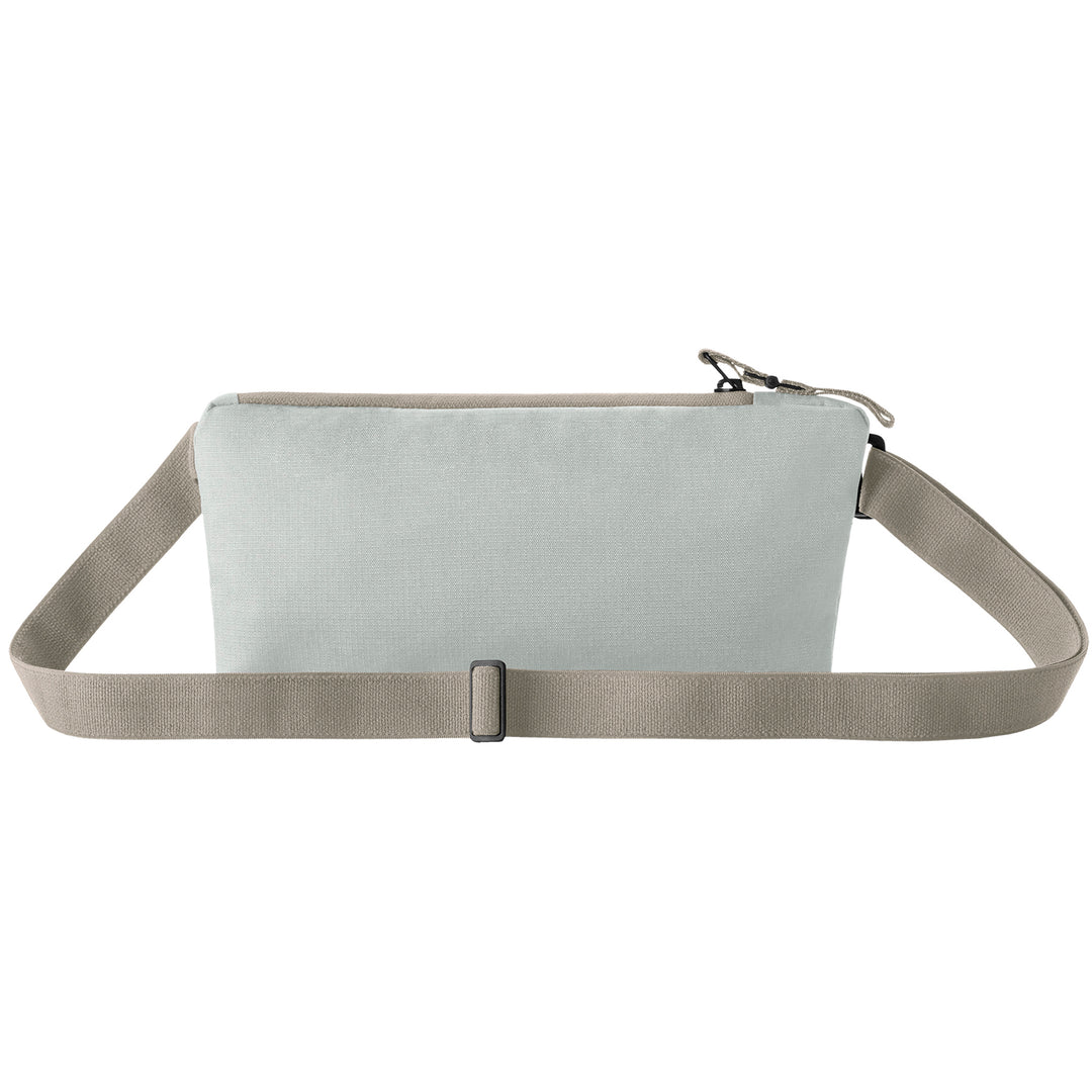 Back side of grey Woman with a grey Eagle Creek Stash RFID Sling Bag showing belt