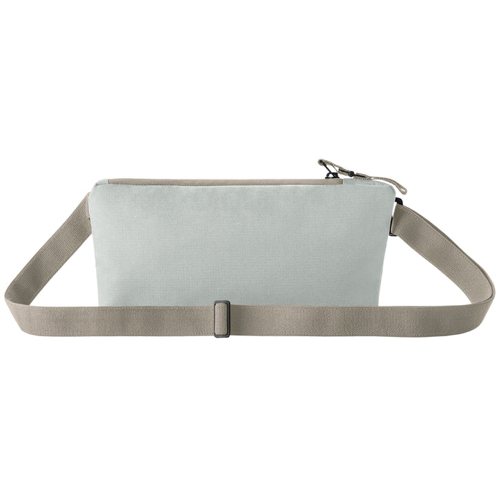 Back side of grey Woman with a grey Eagle Creek Stash RFID Sling Bag showing belt