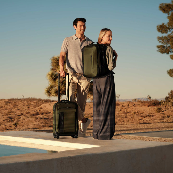 Couple stands by pool at resort with Briggs & Riley ZDX Medium Convertible Backpack Duffle
