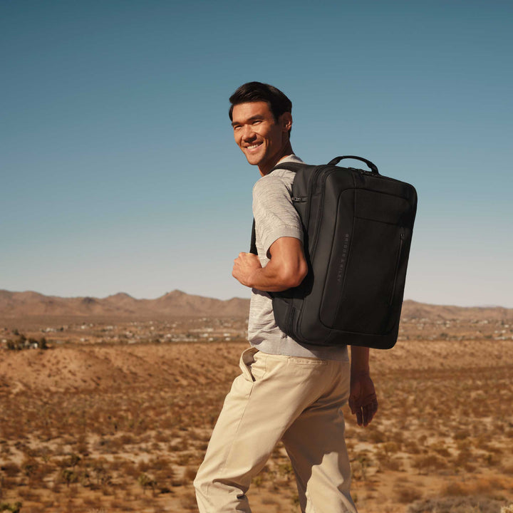 Guy carries  Large Convertible Backpack Duffle in desert hike