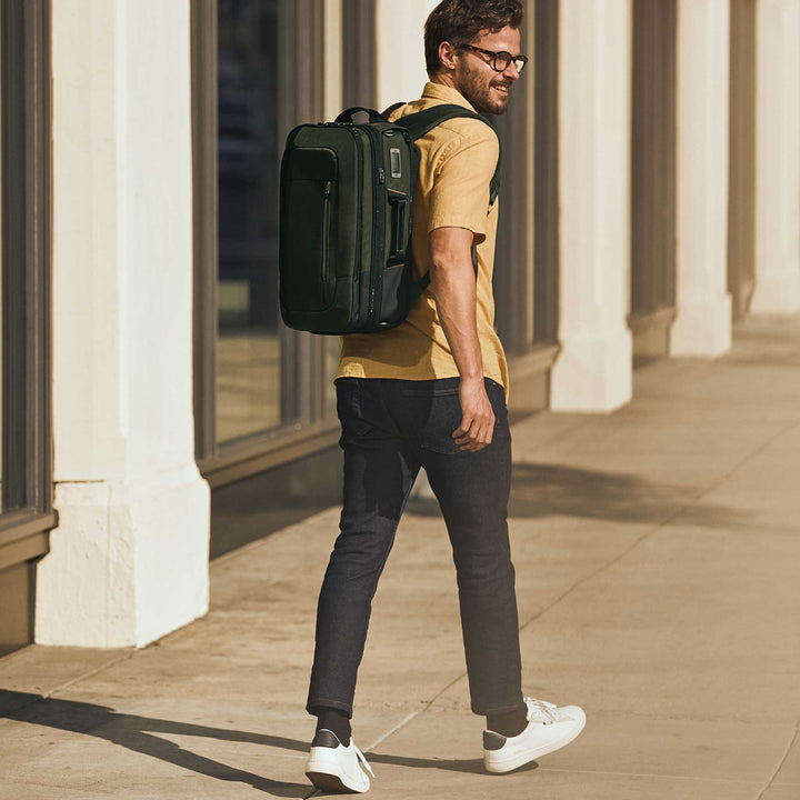 Man walks to work in city with Briggs & Riley ZDX Medium Convertible Backpack Duffle