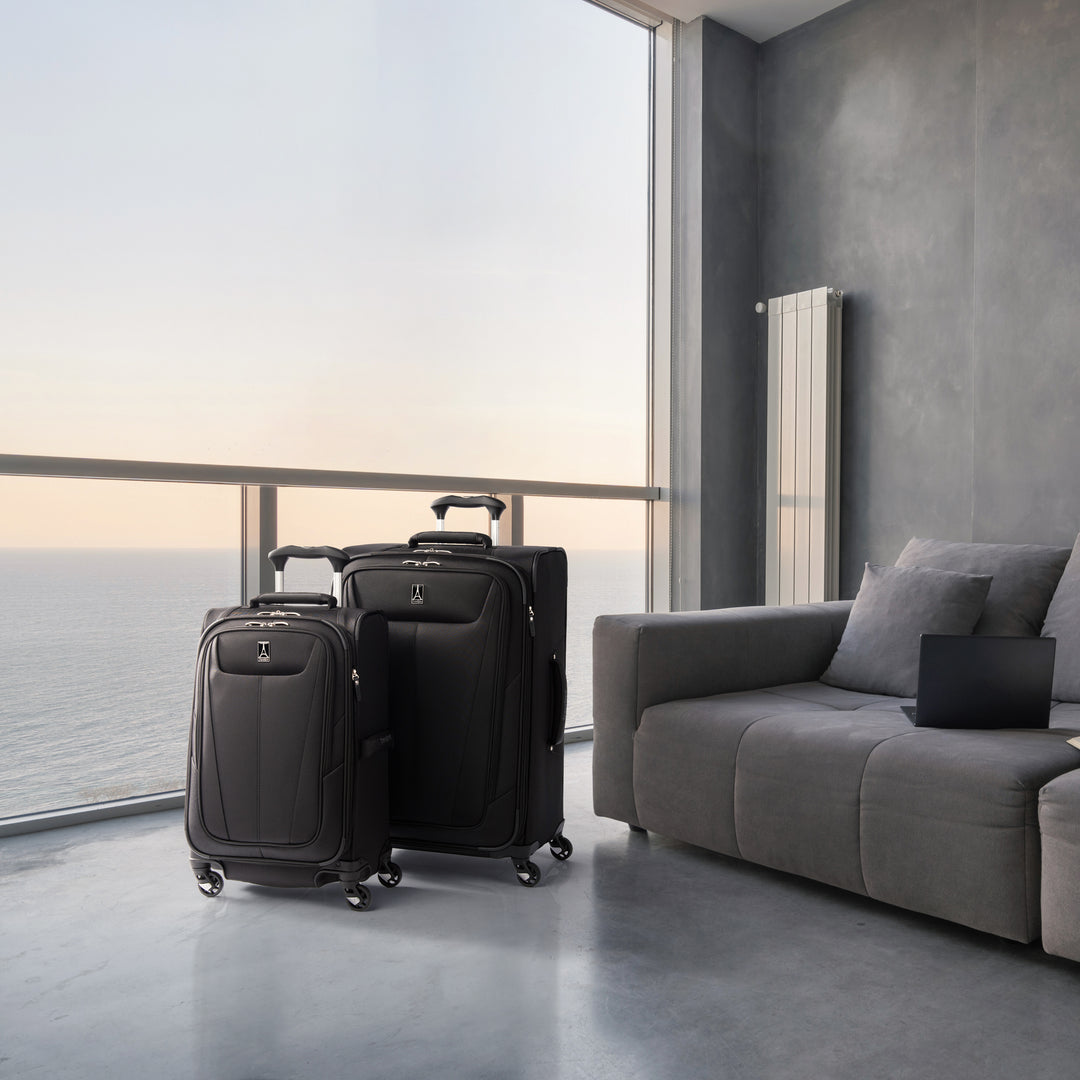 TravelPro Maxlite® 5 Medium Check-In Spinner in color black with matching carry on sitting on hotel balcony at sunset