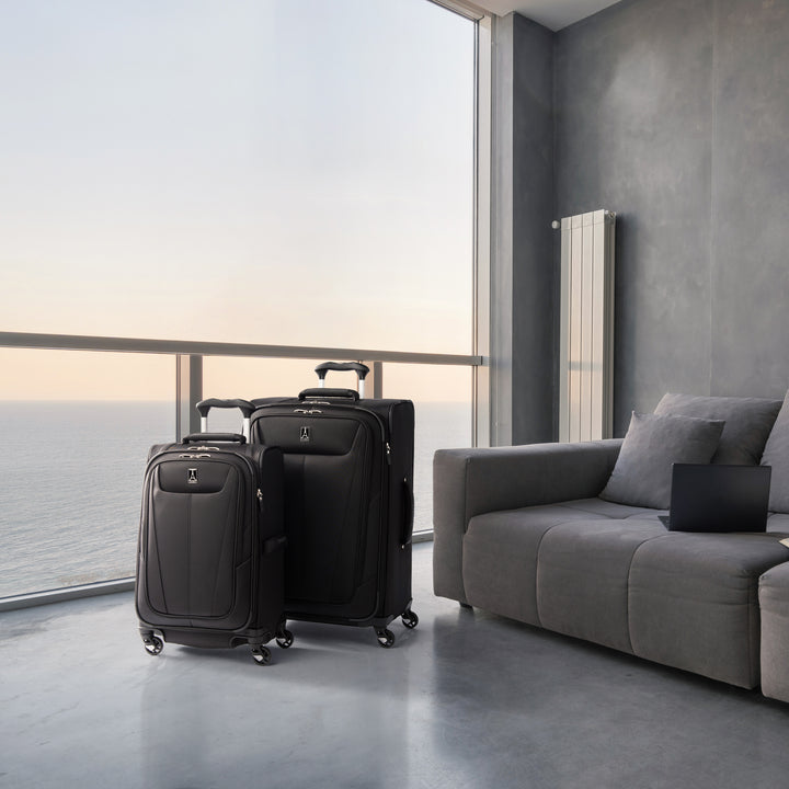 TravelPro Maxlite® 5 Medium Check-In Spinner in color black with matching carry on sitting on hotel balcony at sunset