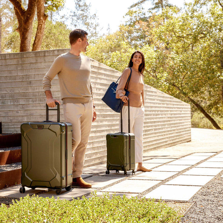 couple checking out of casita with torq hardside luggage in green