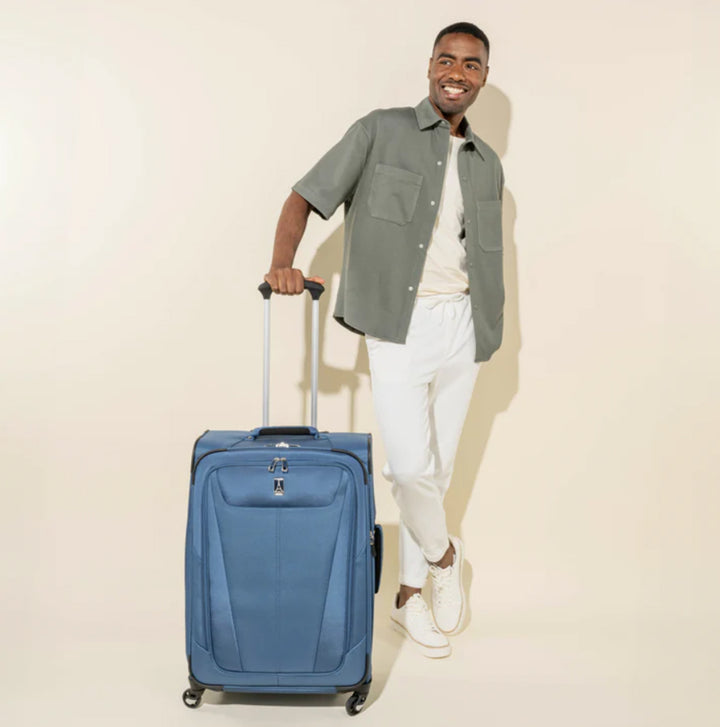 Man holds handle of TravelPro Maxlite® 5 Medium Check-In Spinner  Suitcase in color Ensign Blue to show size