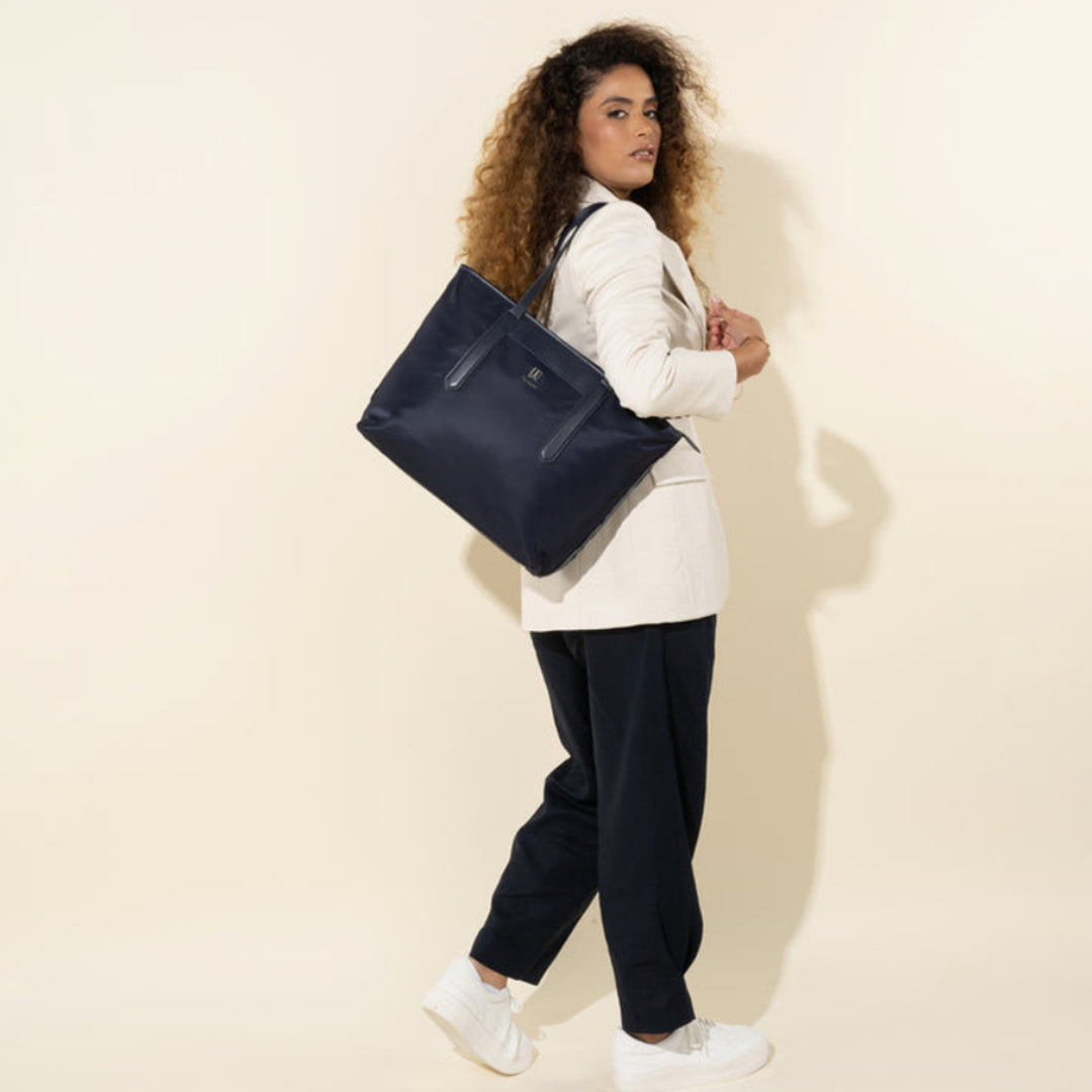 Woman has navy blue Travelpro Crew Executive Choice 3 Women's Tote over her shoulder